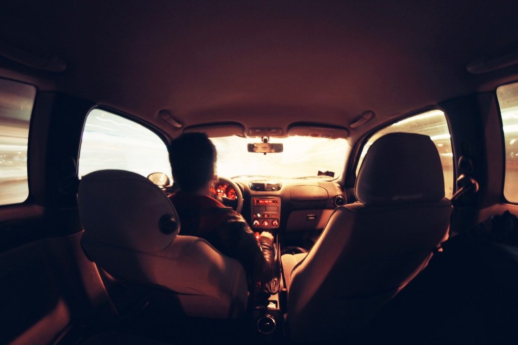a man in the drivers seat of a car